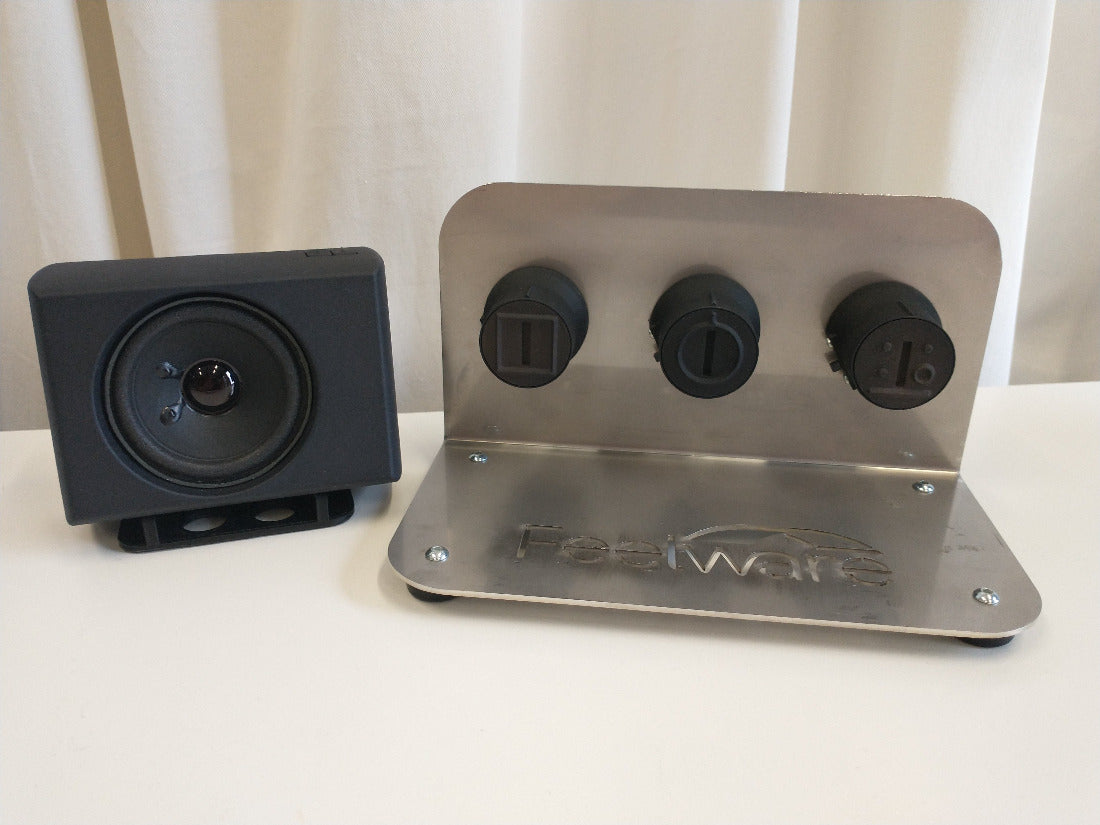 Demokit mit schwarzer AudioBox, einer Halterung mit drei Feelware Bedienknöpfen, zur Auswahl der Garfunktion, Temperaturwahl und Kochstelle.